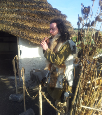 Corwen demonstrating Neolithic music with a swan bone flute at Stonehenge.